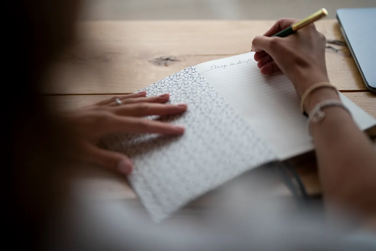Close up of Emma Smalley at Camry House writing on a notebook
